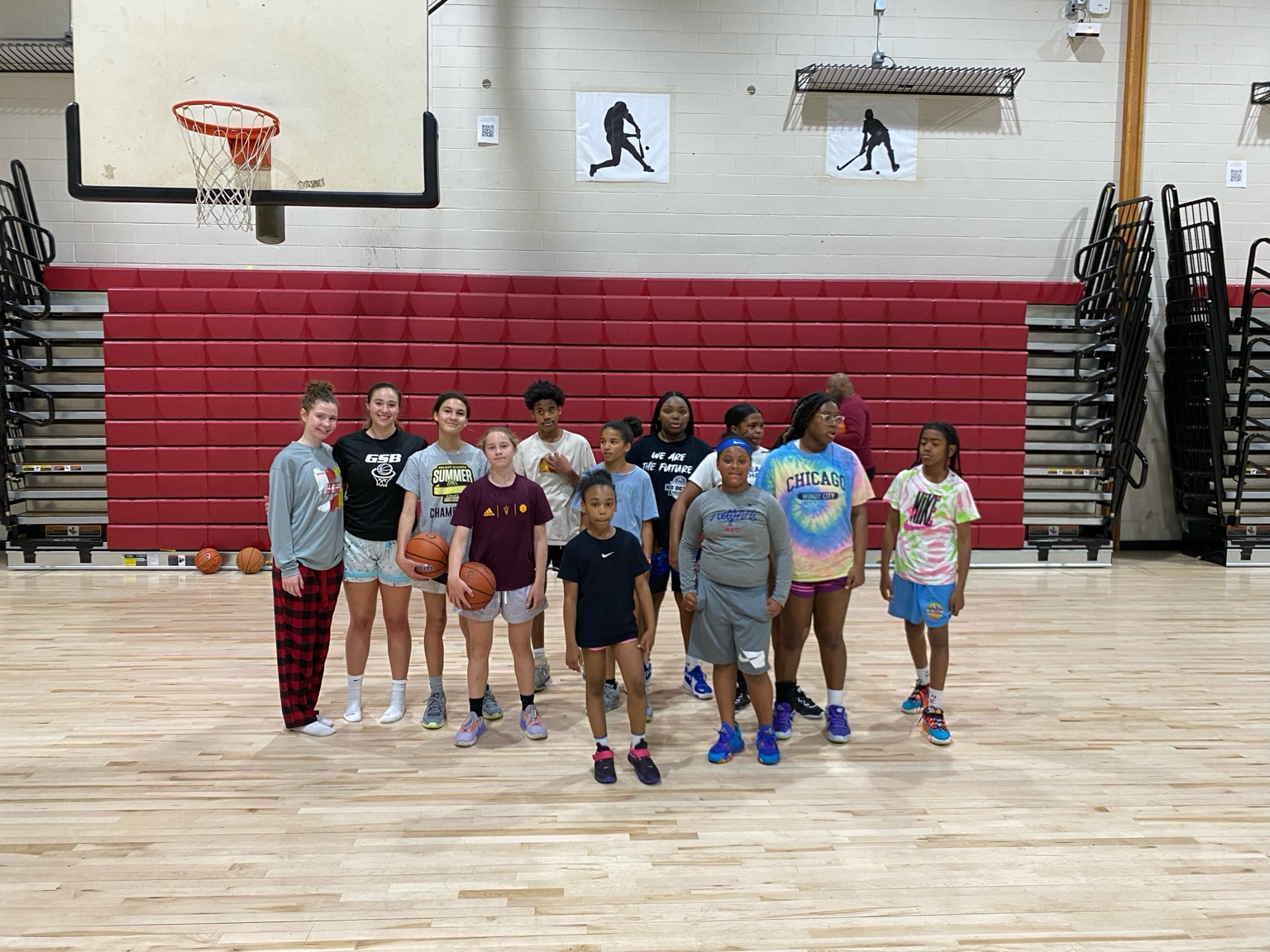 Youth basketball group in front of red bleachers